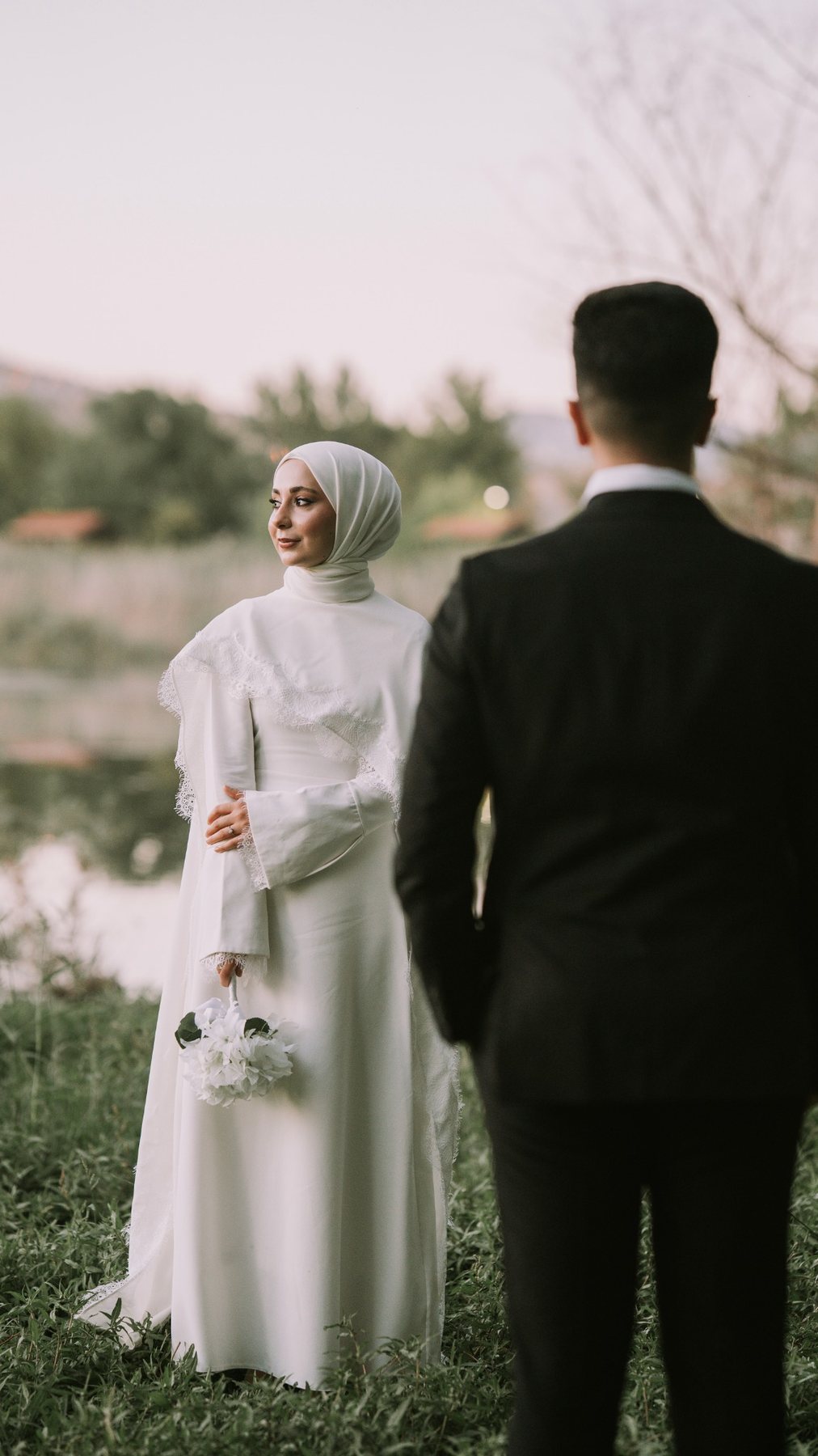 Gelinlik dokusu, el ve buketi öne çıkaran yakın plan.